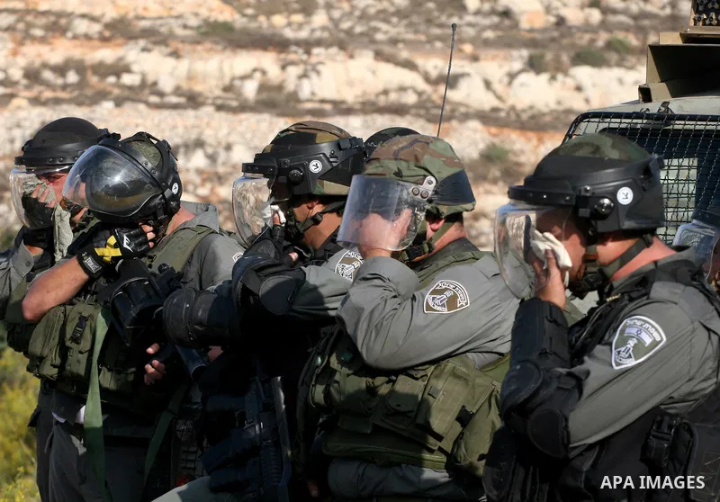 Israeli border police react to tear gas fired at Palestinians during a demonstration calling for the release of prisoners held in Israeli jails and in support of inmates in hunger strike, on October 11, 2011 near Israel'...