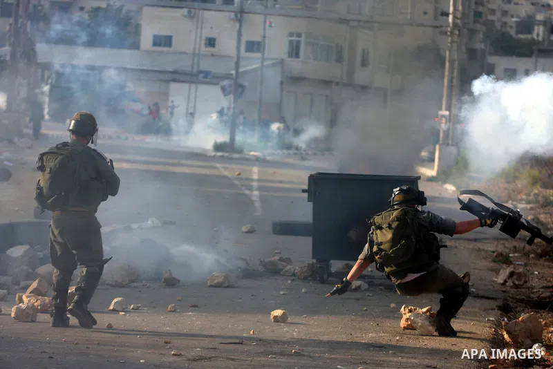An Israeli soldier falls on the ground during clashes with Palestinians following a demonstration calling for the release of prisoners held in Israeli jails and in support of inmates in hunger strike, on October 11, 2011...