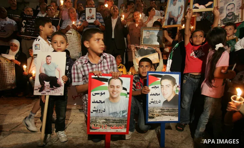 Palestinians take part in a protest calling for the release of Palestinian prisoners from Israeli jails and in support of inmates in hunger strike on October 11, 2011 outside Damascus Gate in Jerusalem's Old City. Accord...