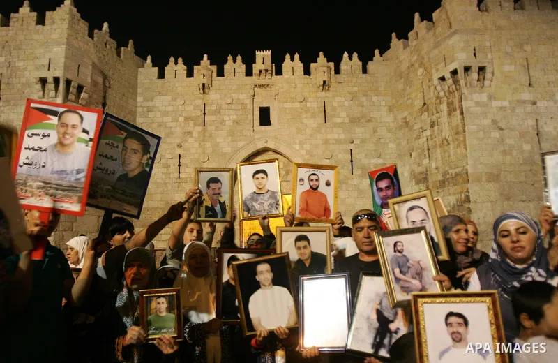 Palestinians take part in a protest calling for the release of Palestinian prisoners from Israeli jails and in support of inmates in hunger strike on October 11, 2011 outside Damascus Gate in Jerusalem's Old City. Both t...