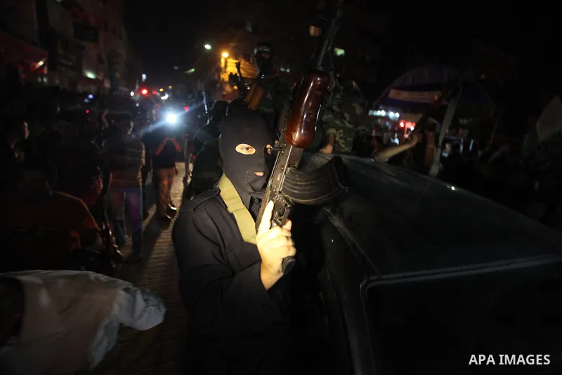 Masked Palestinian Hamas militants celebrate the announcement of a prisoner swap deal with Israel, in the Jebaliya refugee camp northern Gaza Strip, Tuesday, Oct. 11, 2011. Israeli and Hamas have reached a deal to free c...
