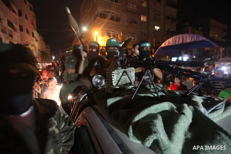 Masked Palestinian Hamas militants celebrate the announcement of a prisoner swap deal with Israel, in the Jebaliya refugee camp northern Gaza Strip, Tuesday, Oct. 11, 2011. Israeli and Hamas have reached a deal to free c...