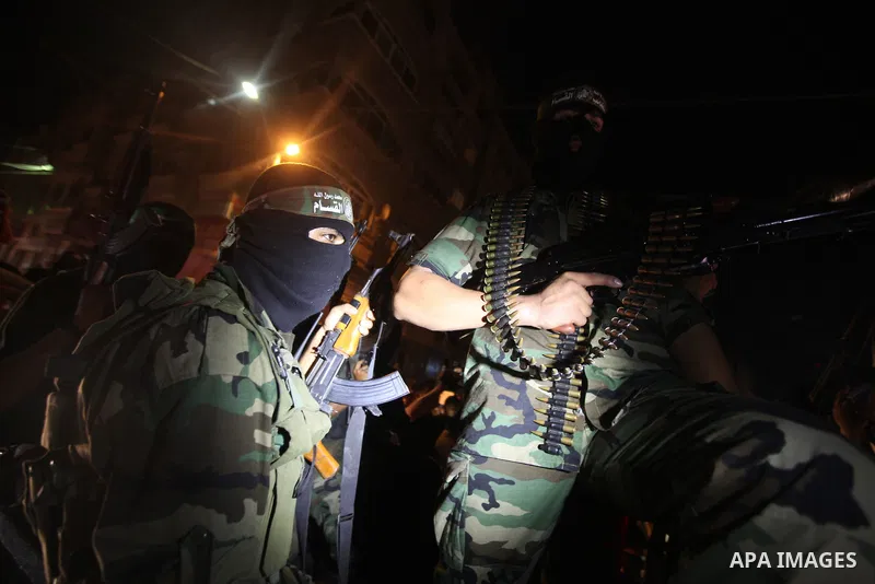 Masked Palestinian Hamas militants celebrate the announcement of a prisoner swap deal with Israel, in the Jebaliya refugee camp northern Gaza Strip, Tuesday, Oct. 11, 2011. Israeli and Hamas have reached a deal to free c...
