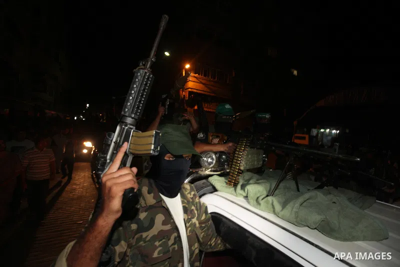 Masked Palestinian Hamas militants celebrate the announcement of a prisoner swap deal with Israel, in the Jebaliya refugee camp northern Gaza Strip, Tuesday, Oct. 11, 2011. Israeli and Hamas have reached a deal to free c...