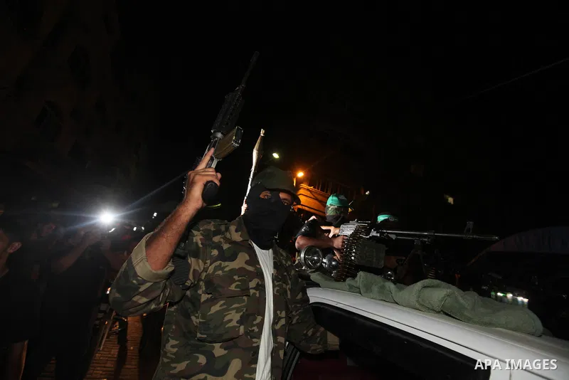 Masked Palestinian Hamas militants celebrate the announcement of a prisoner swap deal with Israel, in the Jebaliya refugee camp northern Gaza Strip, Tuesday, Oct. 11, 2011. Israeli and Hamas have reached a deal to free c...