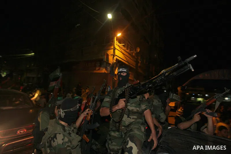 Masked Palestinian Hamas militants celebrate the announcement of a prisoner swap deal with Israel, in the Jebaliya refugee camp northern Gaza Strip, Tuesday, Oct. 11, 2011. Israeli and Hamas have reached a deal to free c...