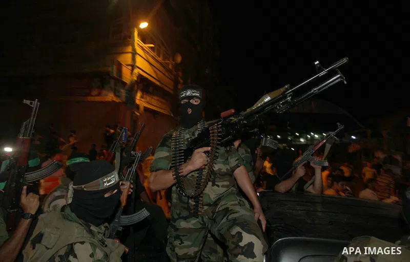 Masked Palestinian Hamas militants celebrate the announcement of a prisoner swap deal with Israel, in the Jebaliya refugee camp northern Gaza Strip, Tuesday, Oct. 11, 2011. Israeli and Hamas have reached a deal to free c...