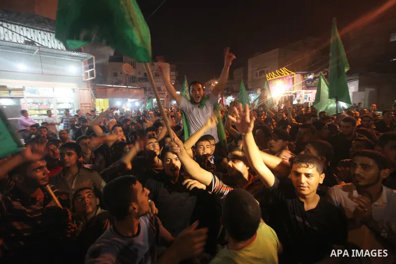 Palestinian Hamas supporters celebrate the announcement of a prisoner swap deal with Israel, in the Jebaliya refugee camp, northern Gaza Strip, Tuesday, Oct. 11, 2011. Israeli and Hamas have reached a deal to free captur...
