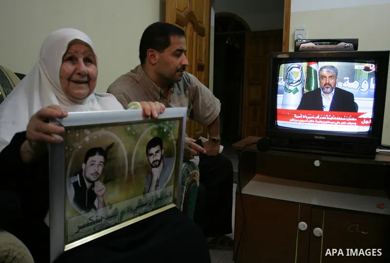 The Family of Hassan Salame, watch a television broadcasting the speech of Hamas leader Khaled Meshaal, celebrating a deal that will see Palestinian detainees freed in exchange for Israeli soldier Gilad Shalit, Hassan Sa...