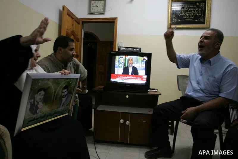 The Family of Hassan Salame, watch a television broadcasting the speech of Hamas leader Khaled Meshaal, celebrating a deal that will see Palestinian detainees freed in exchange for Israeli soldier Gilad Shalit, Hassan Sa...