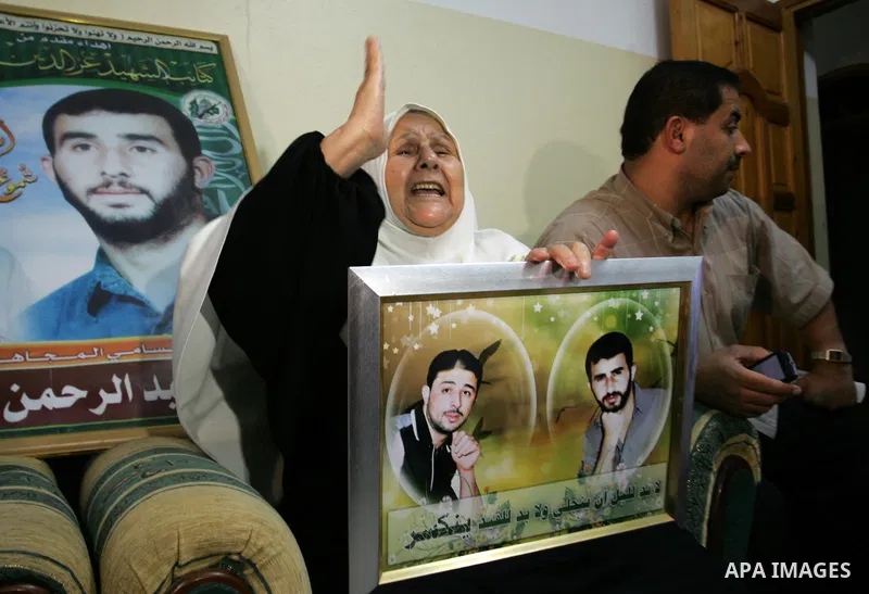 The Family of Hassan Salame, watch a television broadcasting the speech of Hamas leader Khaled Meshaal, celebrating a deal that will see Palestinian detainees freed in exchange for Israeli soldier Gilad Shalit, Hassan Sa...