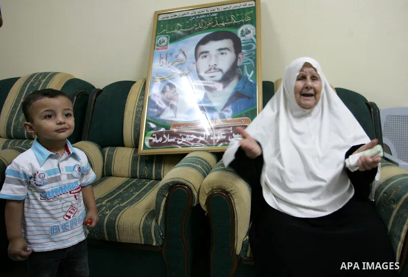 The Family of Hassan Salame, watch a television broadcasting the speech of Hamas leader Khaled Meshaal, celebrating a deal that will see Palestinian detainees freed in exchange for Israeli soldier Gilad Shalit, Hassan Sa...