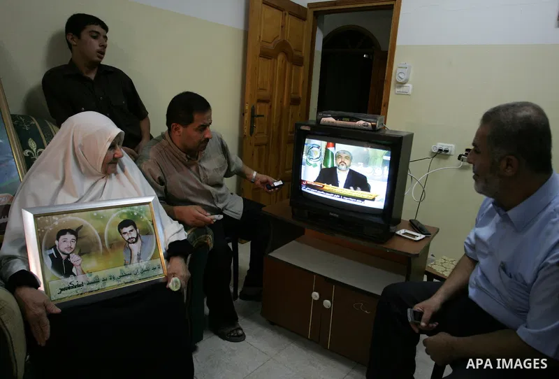 The Family of Hassan Salame, watch a television broadcasting the speech of Hamas leader Khaled Meshaal, celebrating a deal that will see Palestinian detainees freed in exchange for Israeli soldier Gilad Shalit, Hassan Sa...