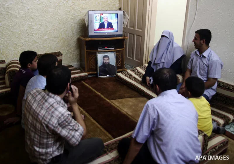 Relatives of Palestinian prisoner Rawhy Mushtaha, held in an Israeli jail, sit in thier house in Gaza City, as they watch a television broadcast of Hamas leader Khaled Meshaal speaking in Damascus, October 11, 2011. Isra...