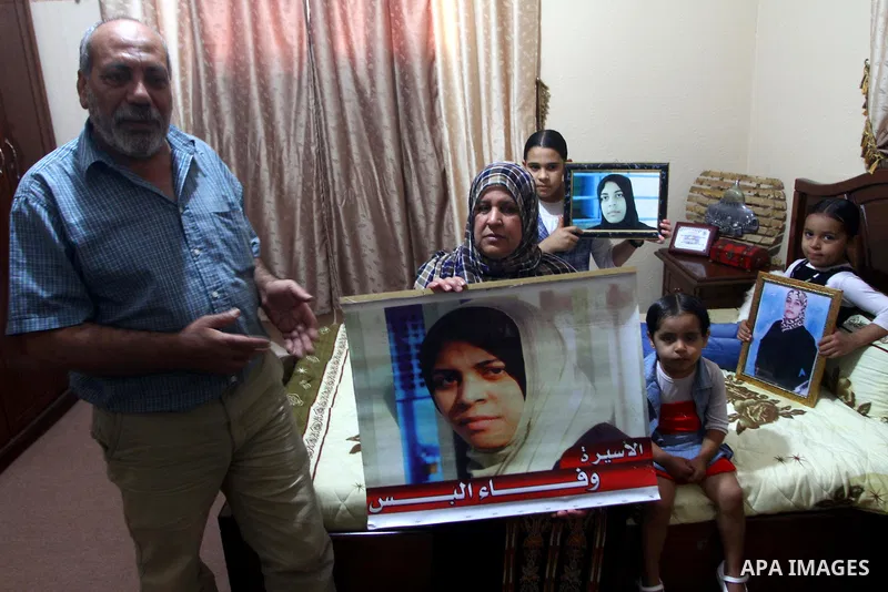 The family of Palestinian prisoner Wafa Albes hold portraits of her as they prepare their house for her upcoming release from an Israeli jail on Oct, 12, 2011 in the Jabalia refugee camp. Wafa has been jailed in Israel s...