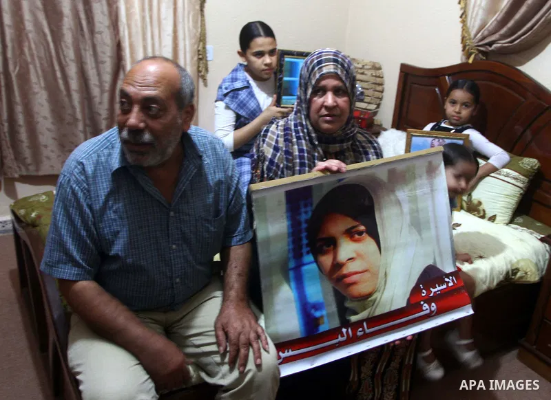 The family of Palestinian prisoner Wafa Albes hold portraits of her as they prepare their house for her upcoming release from an Israeli jail on Oct, 12, 2011 in the Jabalia refugee camp. Wafa has been jailed in Israel s...
