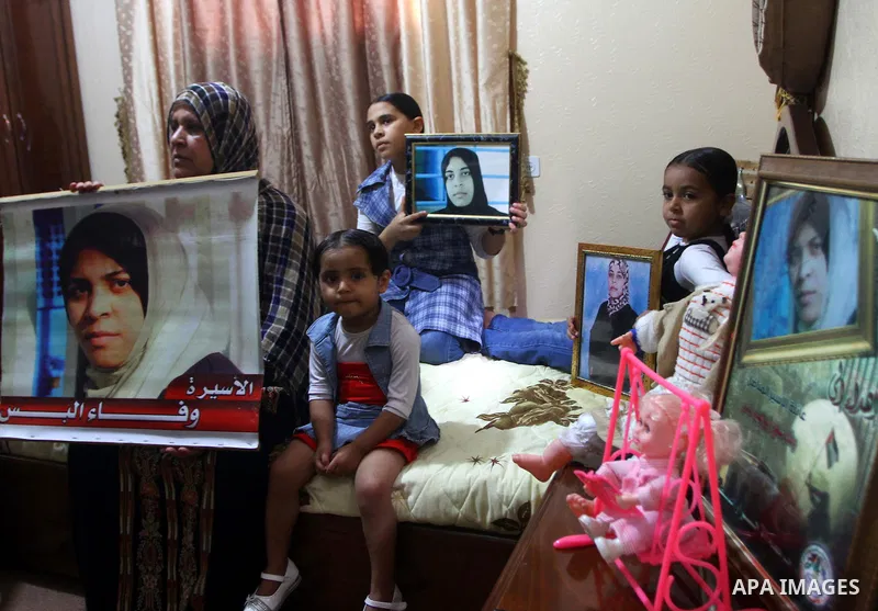 The family of Palestinian prisoner Wafa Albes hold portraits of her as they prepare their house for her upcoming release from an Israeli jail on Oct, 12, 2011 in the Jabalia refugee camp. Wafa has been jailed in Israel s...