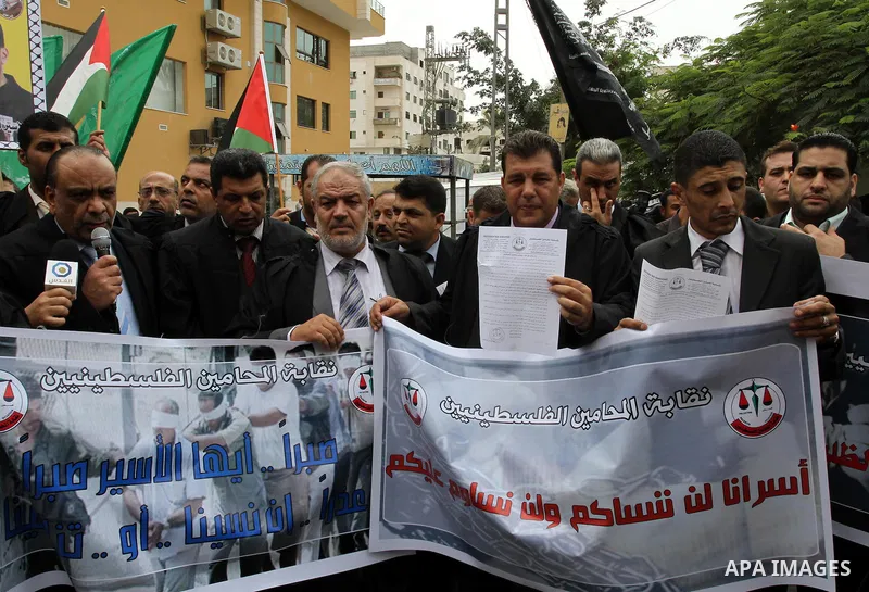 Palestinian lawyers demonstrate in solidarity with prisoners jailed in Israel in front of the International Red Cross building in Gaza City, Wednesday, Oct. 12, 2011. Israelis welcomed on Wednesday a major prisoner swap...