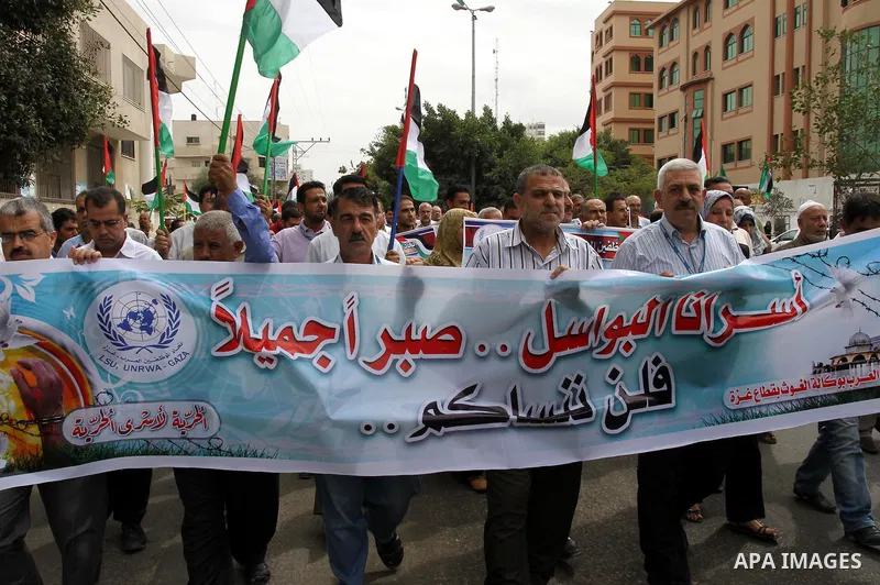 Palestinian UNRWA employees demonstrate in solidarity with prisoners jailed in Israel in front of the International Red Cross building in Gaza City, Wednesday, Oct. 12, 2011. Israelis welcomed on Wednesday a major prison...