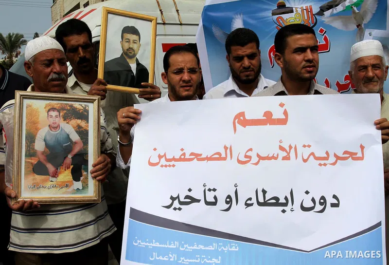 Palestinian journalists demonstrate in solidarity with prisoners jailed in Israel in front of the International Red Cross building in Gaza City, Wednesday, Oct. 12, 2011. Israelis welcomed on Wednesday a major prisoner s...
