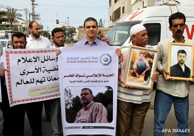 Palestinian journalists demonstrate in solidarity with prisoners jailed in Israel in front of the International Red Cross building in Gaza City, Wednesday, Oct. 12, 2011. Israelis welcomed on Wednesday a major prisoner s...