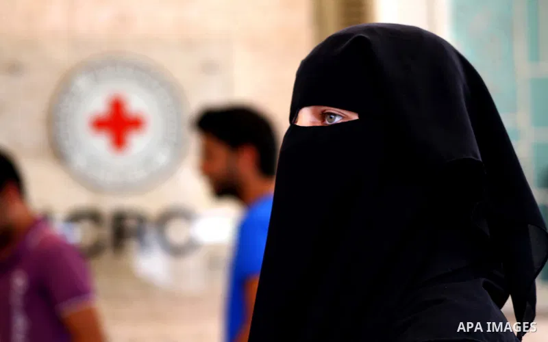 Veiled Palestinian woman walks in front of the red cross headquarters during a rally after a prisoner swap between Hamas and Israel, in Gaza City October 12, 2011. Israelis welcomed on Wednesday a major prisoner swap tha...