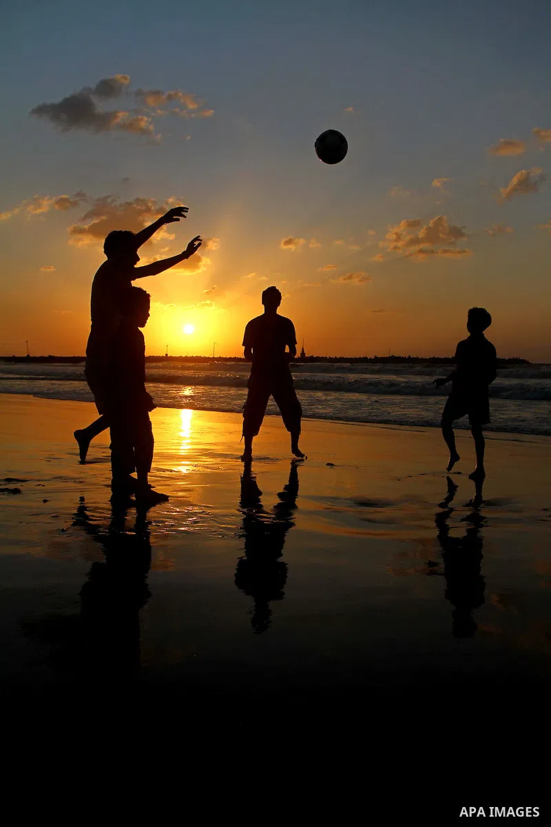 Children play football at the beach during sunset as Palestinians celebrating a prisoner swap between Hamas and Israel, in Gaza City October 12, 2011. Israelis welcomed on Wednesday a major prisoner swap that will free s...