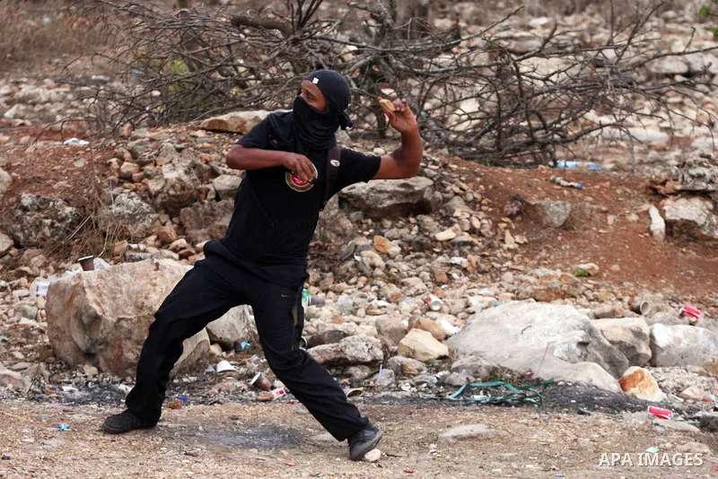 Masked Palestinian stone-throwers are seen during clashes with Israeli border police, not pictured, outside the Ofer military prison near the West Bank city of Ramallah, Wednesday, Oct. 12, 2011. Photo by Issam Rimawi