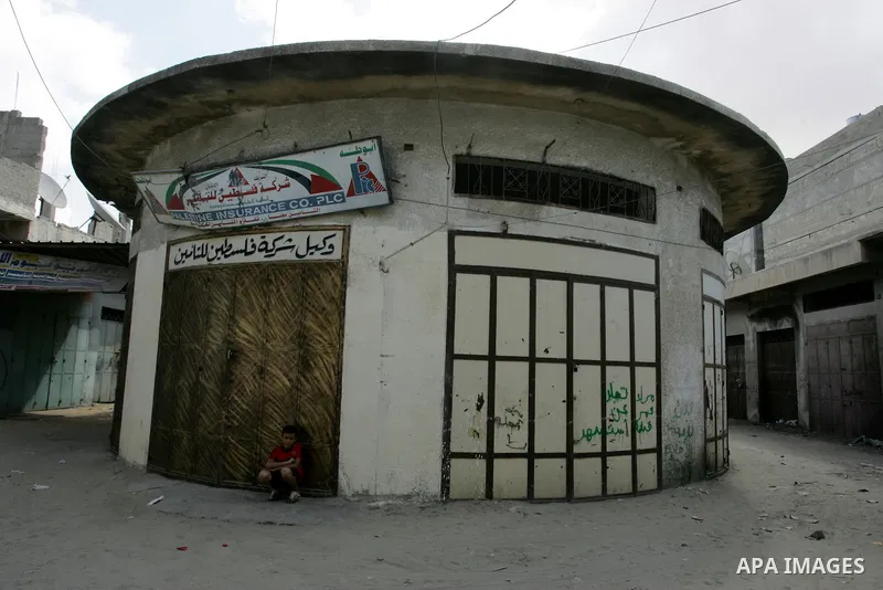 A Palestinian boy walks in front of closed shops following a two-hour strike in solidarity with Palestinian prisoners held in Israeli jails, in Rafah, southern Gaza Strip on October 13, 2011. According to an Israeli Pris...
