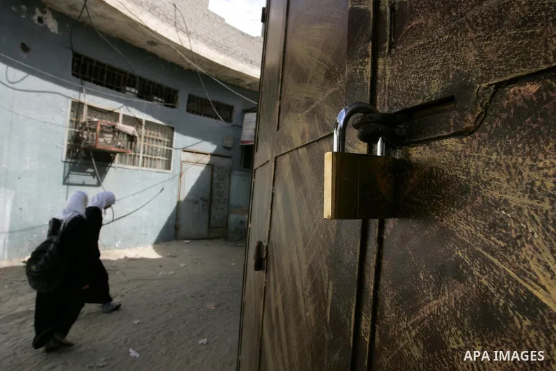 Palestinian schoolgirls walk in front of closed shops following a two-hour strike in solidarity with Palestinian prisoners held in Israeli jails, in Rafah, southern Gaza Strip on October 13, 2011. According to an Israeli...