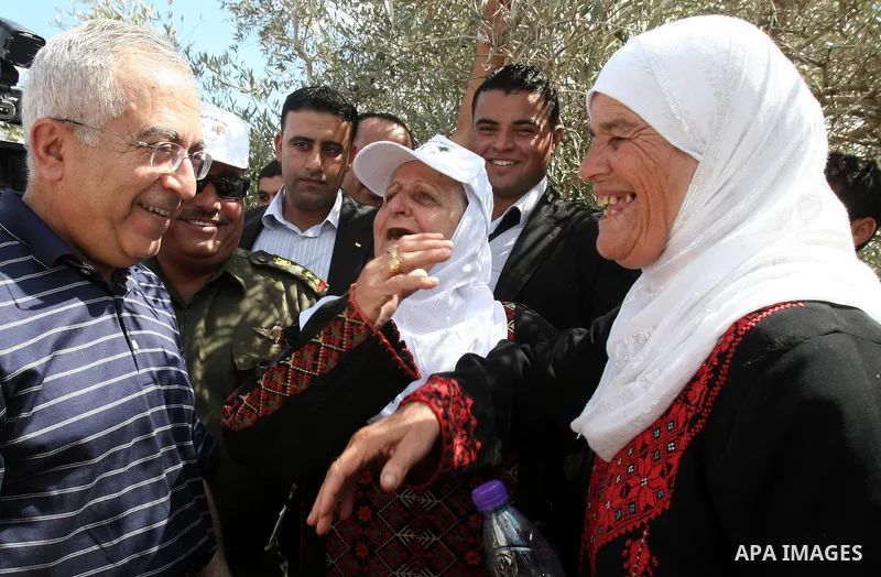 Palestinian Prime Minister Salam Fayyad speaks with Palestinian farmers during his visit at the beginning of olive harvest season in the West Bank village of Feraon, near Tulkarem, Thursday, Oct. 13, 2011. A Hamas offici...