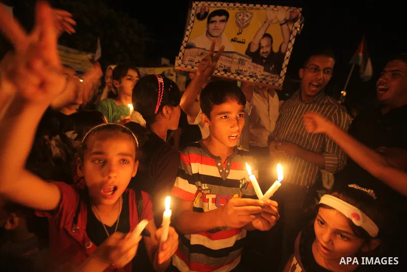 Palestinian children hold candles during a rally in solidarity with Palestinian prisoners held in Israeli jails, in Gaza City October 13, 2011. Israeli soldier Gilad Shalit will be freed from five years of captivity in t...