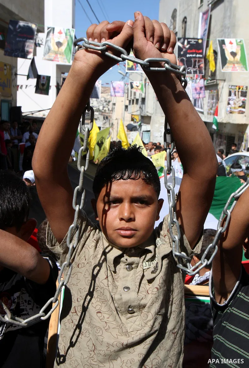 Palestinians take part in a rally supporting the prisoners in Israeli jails in the Askar refugee camp in the West Bank city of Nablus, Friday Oct. 14, 2011. The case of prisoners in Israeli jails is deeply sensitive for...