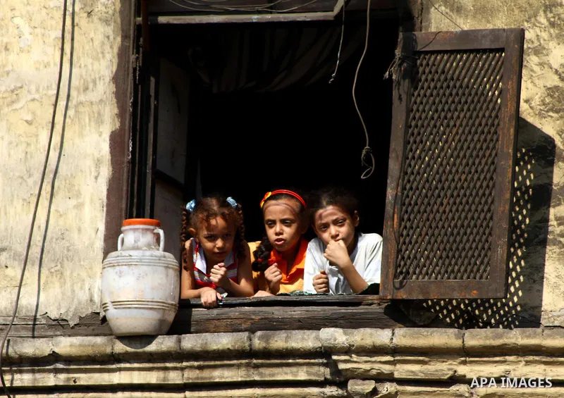 Egyptian girls watch protesters shout slogans during a demonstration outside a mosque in Cairo in support of national unity that led to a clash between pro- and anti-military supporters on October 14, 2011. The military...