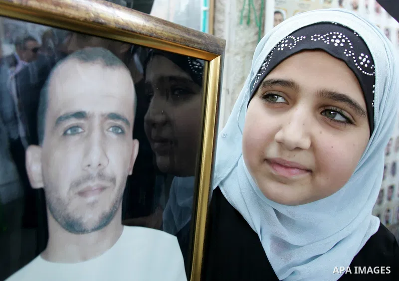 Palestinians hold photographs of their relatives held in Israeli jails during a protest calling for their release, next to the headquarters of the International Red Cross in Jerusalem, October 14, 2011. Israeli soldier G...
