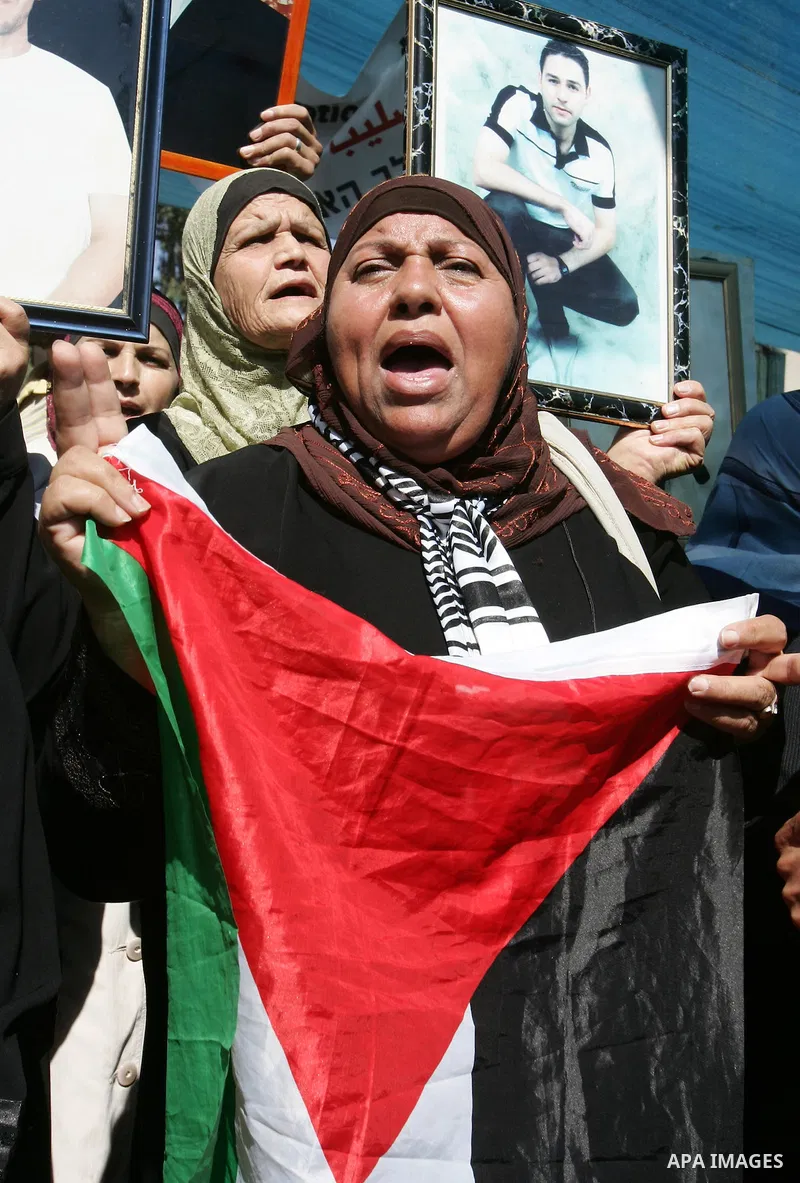 Palestinians hold photographs of their relatives held in Israeli jails during a protest calling for their release, next to the headquarters of the International Red Cross in Jerusalem, October 14, 2011. Israeli soldier G...