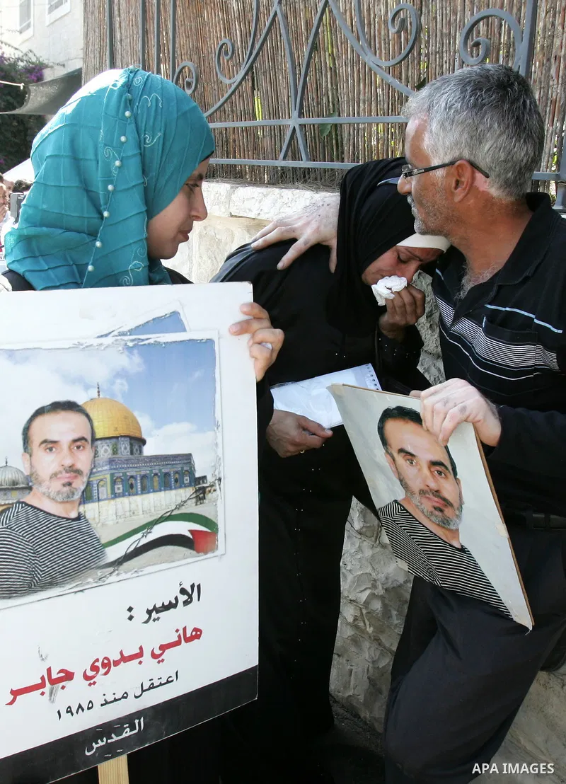 Palestinians hold photographs of their relatives held in Israeli jails during a protest calling for their release, next to the headquarters of the International Red Cross in Jerusalem, October 14, 2011. Israeli soldier G...