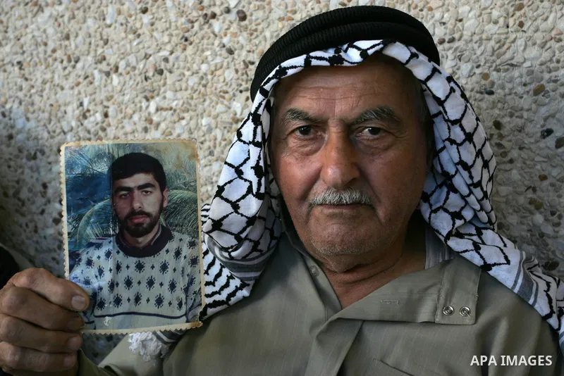 The family of Palestinian prisoner Nasser Nazzal show his picture as they gather at a relative's house in the southern Gaza Strip town of Khan Younis on October 15, 2011 awaiting his release as part of a deal to secure t...
