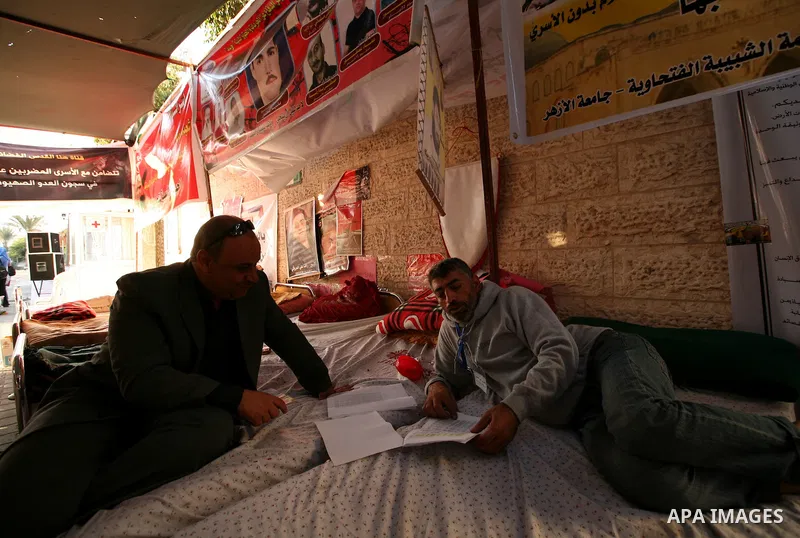 Palestinians look at the lists of Palestinian prisoners, who are to be exchanged for captured Israeli soldier Gilad Schalit, in Gaza City, Sunday, Oct. 16, 2011. The relatives of Israelis killed in Palestinian attacks wa...