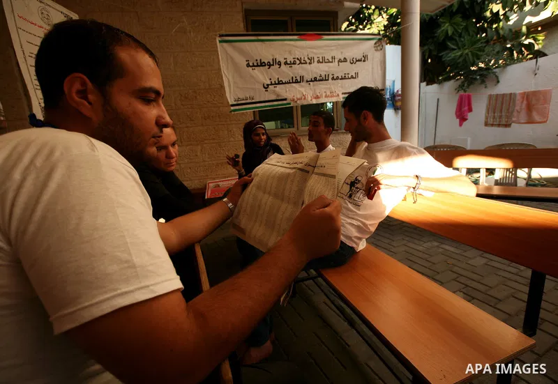 Palestinians look at the lists of Palestinian prisoners, who are to be exchanged for captured Israeli soldier Gilad Schalit, published in the newspapers in Gaza City, Sunday, Oct. 16, 2011. The relatives of Israelis kill...