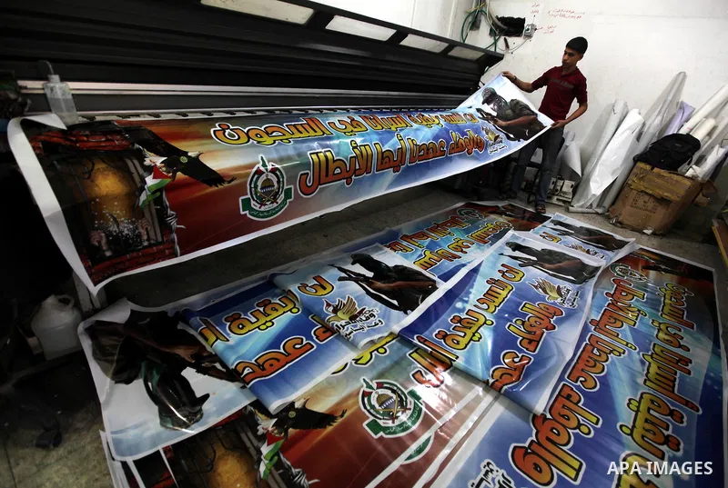Palestinians print posters in preparation for a prisoner swap between Hamas and Israel in Gaza City, Sunday, Oct. 16, 2011. Relatives of Israelis killed in Palestinian attacks waged a charged debate Sunday over the plann...