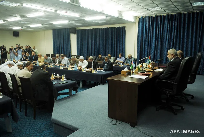 Palestinian Prime Minister in Gaza Strip, Ismail Haniyeh attends a meeting with his ministers and legislators in his office in Gaza City, Sunday, Oct. 16, 2011. The relatives of Israelis killed in Palestinian attacks wag...