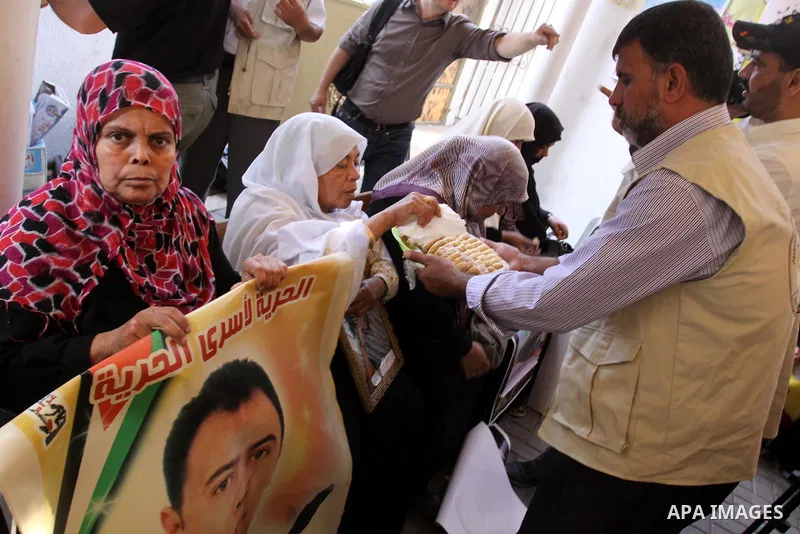 Relatives of Palestinian prisoners eat sweets as they celebrate the upcoming release of Palestinian inmates held in Israeli jails, on Oct. 17, 2011 at the Red Cross' offices in Gaza City. Under a prisoner swap deal signe...