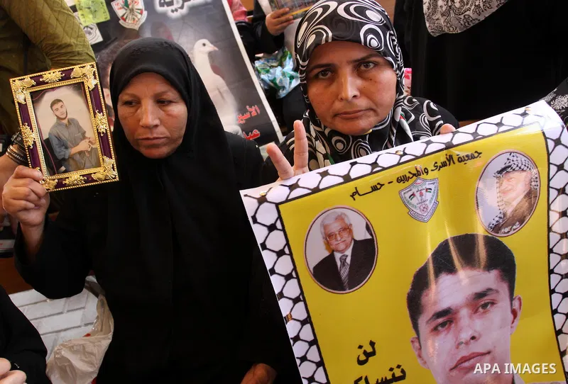 Relatives of Palestinian prisoners eat sweets as they celebrate the upcoming release of Palestinian inmates held in Israeli jails, on Oct. 17, 2011 at the Red Cross' offices in Gaza City. Under a prisoner swap deal signe...