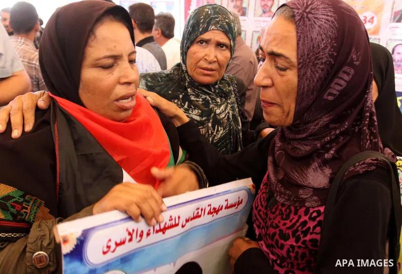 Relatives of Palestinian prisoners eat sweets as they celebrate the upcoming release of Palestinian inmates held in Israeli jails, on Oct. 17, 2011 at the Red Cross' offices in Gaza City. Under a prisoner swap deal signe...