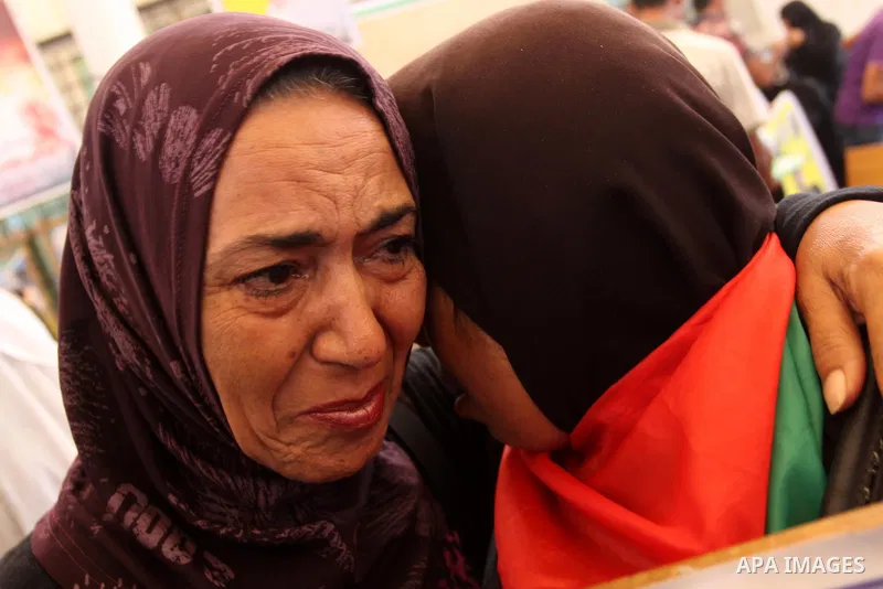 Relatives of Palestinian prisoners eat sweets as they celebrate the upcoming release of Palestinian inmates held in Israeli jails, on Oct. 17, 2011 at the Red Cross' offices in Gaza City. Under a prisoner swap deal signe...