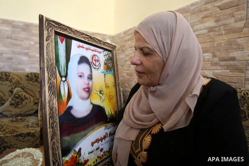 Entesar jayyousi, mother of Palestinian female prisoner doaa jayyousi sentenced to three life sentences in prison Damon , sits next to a photo of her at the family home in the West Bank city of Tulkarem as she reacts to...