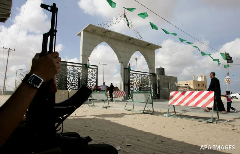 A Palestinian Hamas supporter hangs green Islamic flags as decoration ahead of the upcoming prisoner swap, at the entrance to the Rafah border crossing, southern Gaza Strip, Monday, Oct. 17, 2011. The exchange between Is...