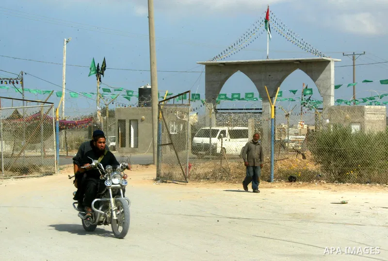 A Palestinian Hamas supporter hangs green Islamic flags as decoration ahead of the upcoming prisoner swap, at the entrance to the Rafah border crossing, southern Gaza Strip, Monday, Oct. 17, 2011. The exchange between Is...