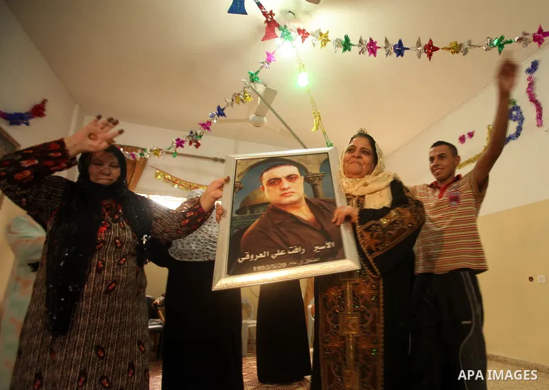 The family of Palestinian prisoner Raafat Aroki gather at a relative's house in the Gaza Strip on 17 October 2011 as they await his release as part of a deal to secure the exchange of Israeli captive soldier Gilad Shalit...